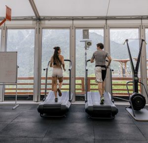 A couple working hard on a treadmill in a gym